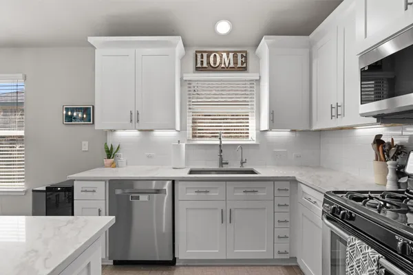 a kitchen with stainless steel appliances granite countertop a sink and a stove