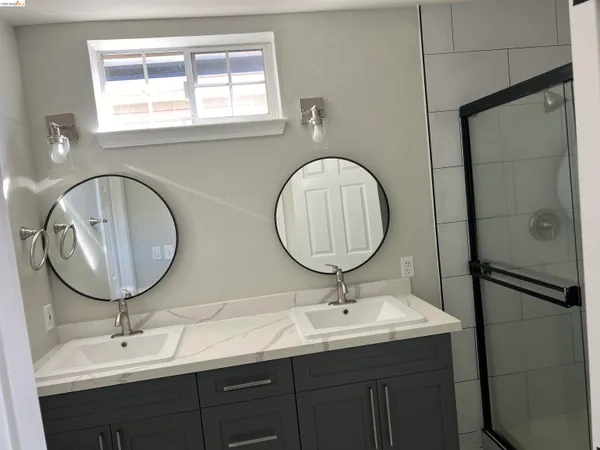 a bathroom with a double vanity sink and a mirror