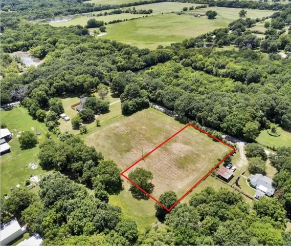 an aerial view of residential house with outdoor space and trees all around