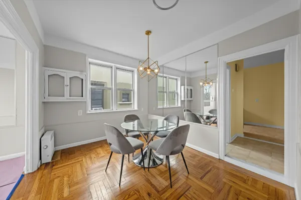 a dining room with furniture a chandelier and wooden floor
