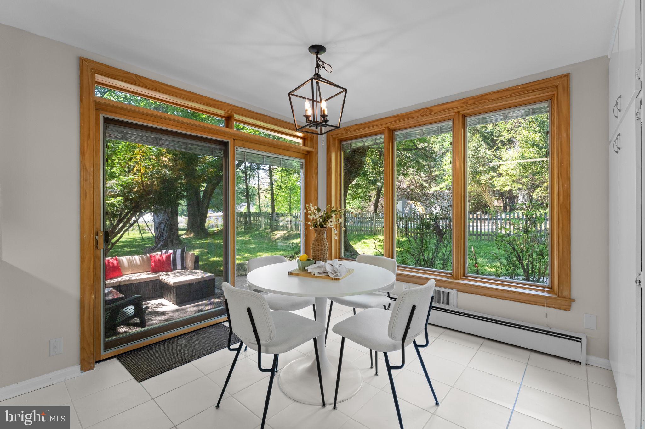 11712 Berwick Road Silver Spring, MD 20904 - Photo 8 of 42 a dining room with wooden floor a chandelier a glass table and chairs