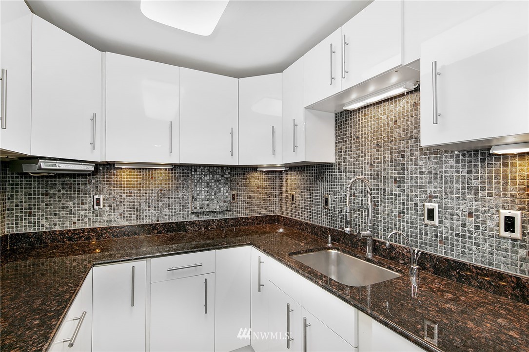 931 North 85th Street, Unit 5 Seattle, WA 98103 - Photo 9 of 11 a kitchen with granite countertop a sink a stove a microwave and cabinets