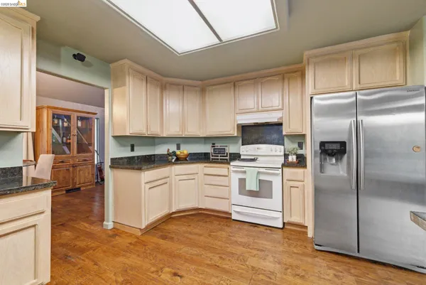 a bathroom with a granite countertop sink a mirror and a toilet