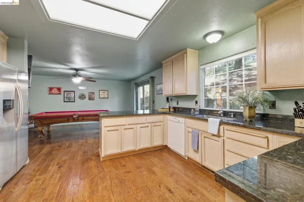 a kitchen with stainless steel appliances granite countertop a stove and white cabinets