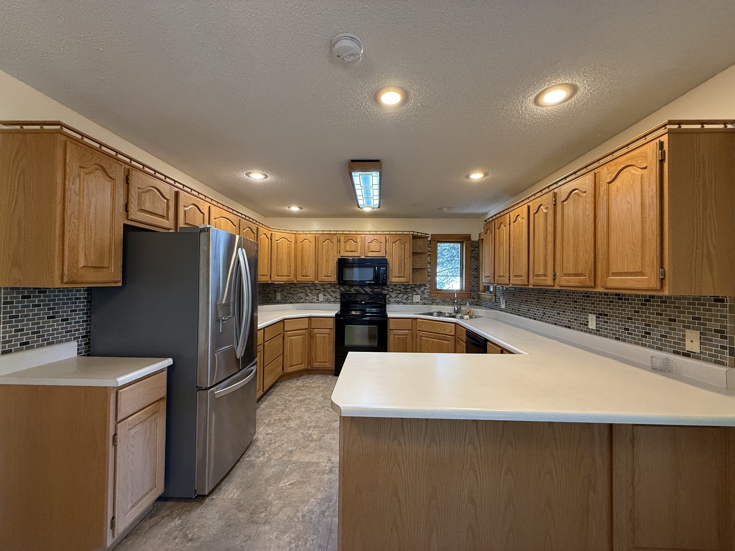 136 Bonnie Brae Road Carbondale, IL 62901 - Photo 8 of 30 a kitchen with stainless steel appliances wooden cabinets a sink and a refrigerator