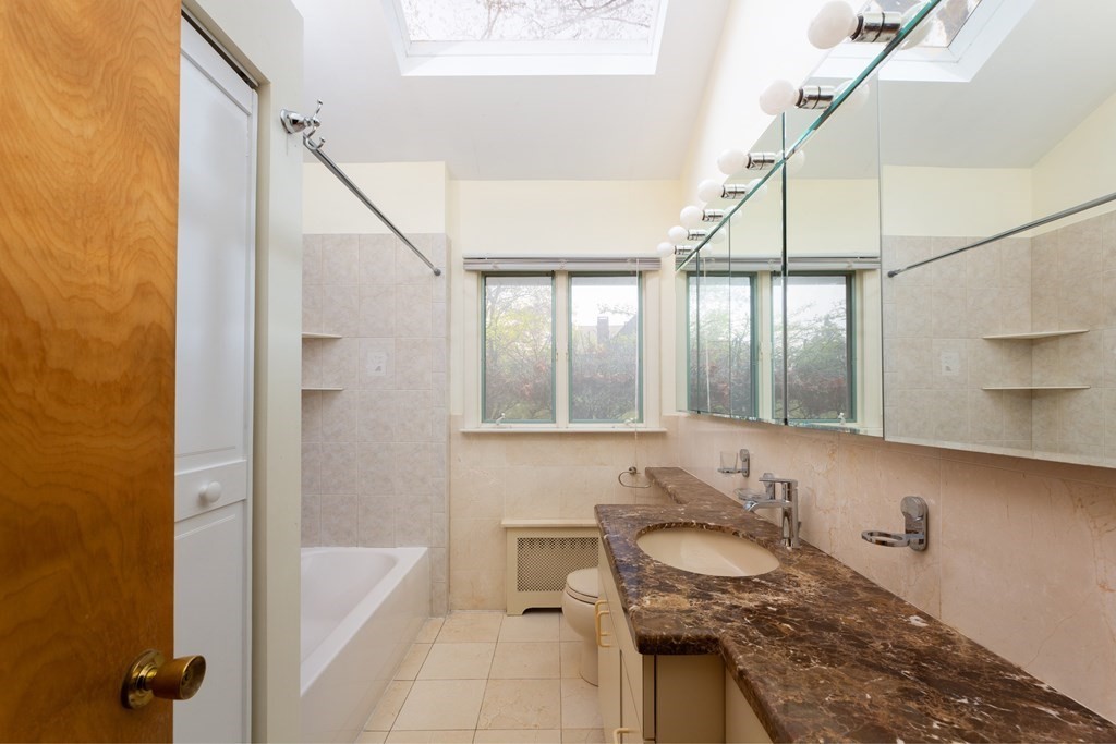 39 Cedarwood Road Boston, MA 02130 - Photo 10 of 11 a bathroom with a granite countertop sink a mirror and a bathtub