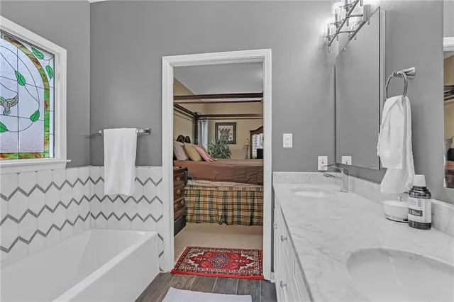 a bathroom with a bathtub sink and mirror