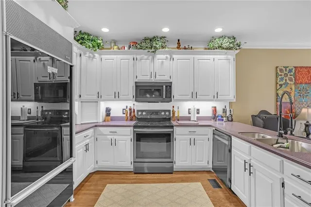 a kitchen with a sink stainless steel appliances and cabinets