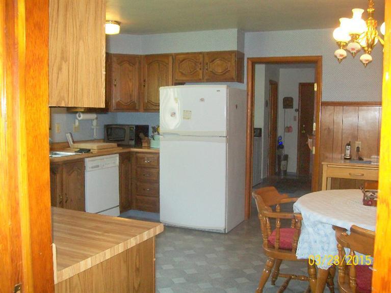 5015 Waldo Road Cave Junction, OR 97523 - Photo 3 of 35 a kitchen with a refrigerator a stove top oven a sink dishwasher and dining table with wooden floor