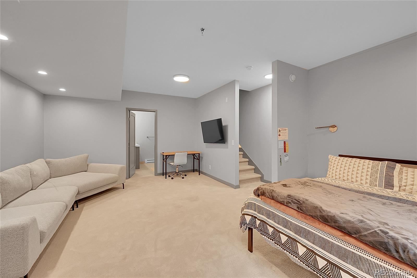 4158 Longview Lane Boulder, CO 80301 - Photo 6 of 15 a bedroom with a bed a flat screen tv and couches