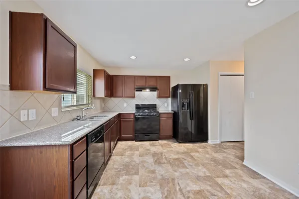a kitchen with stainless steel appliances granite countertop a refrigerator and a sink