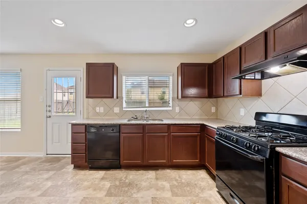 a kitchen with stainless steel appliances granite countertop a sink stove and cabinets