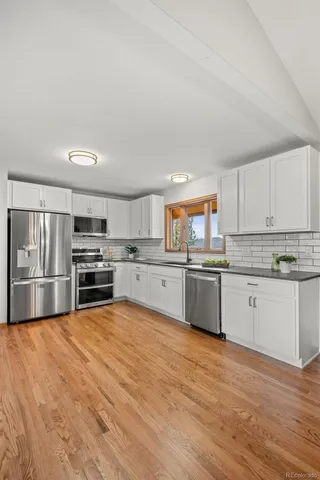 a kitchen with stainless steel appliances and white cabinets