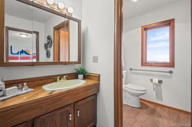 a bathroom with a toilet a sink and mirror