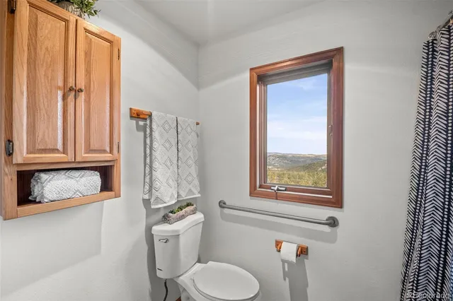 a bathroom with a toilet a sink and a window