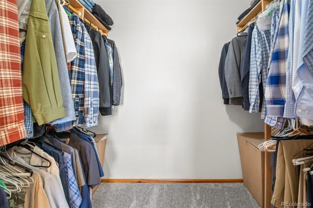 a view of walk in closet with clothes and shoes