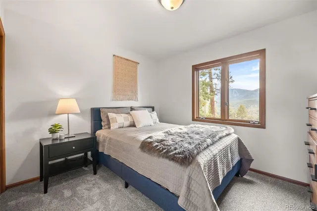 a bedroom with a bed and a lamp next to a window