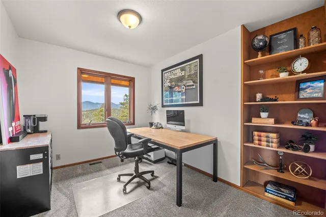 a view of a workspace with furniture and a workspace