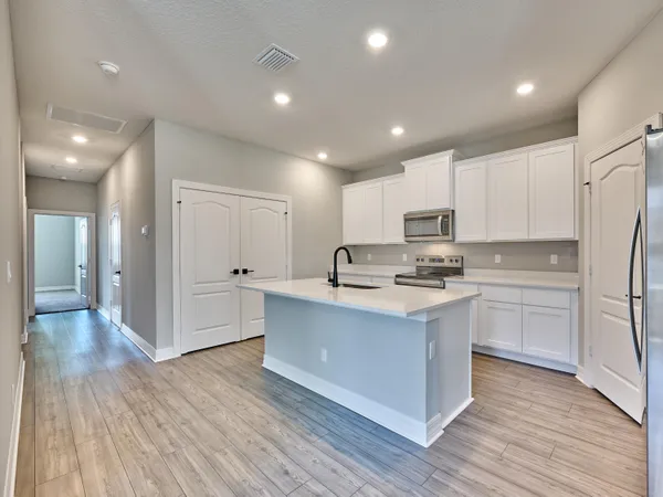 a kitchen with a sink cabinets and wooden floor