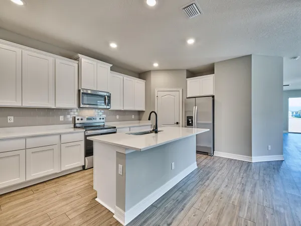 a kitchen with stainless steel appliances granite countertop a sink and a stove top oven