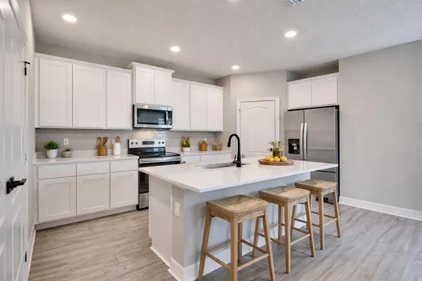 a kitchen with stainless steel appliances a stove a sink and a refrigerator