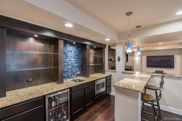 a kitchen with granite countertop a sink and a refrigerator