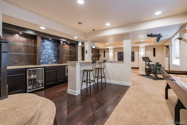 a living room with stainless steel appliances furniture and wooden floor
