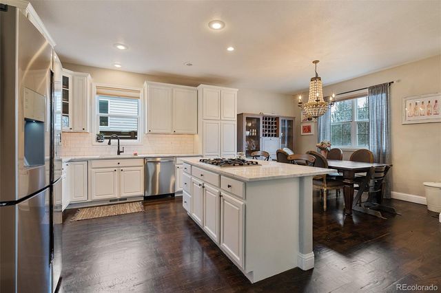 a kitchen with white cabinets stove and refrigerator