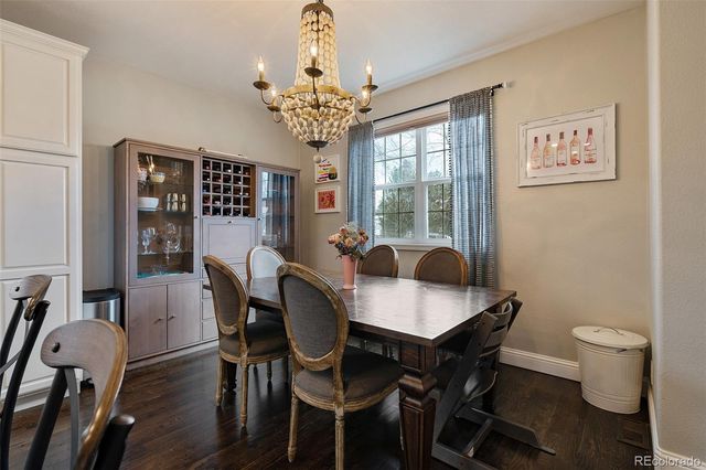 a view of a dining room with furniture a chandelier and wooden floor