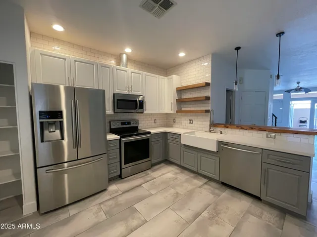 a large kitchen with a refrigerator sink and microwave