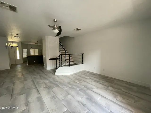 a view of a livingroom with wooden floor and a chandelier