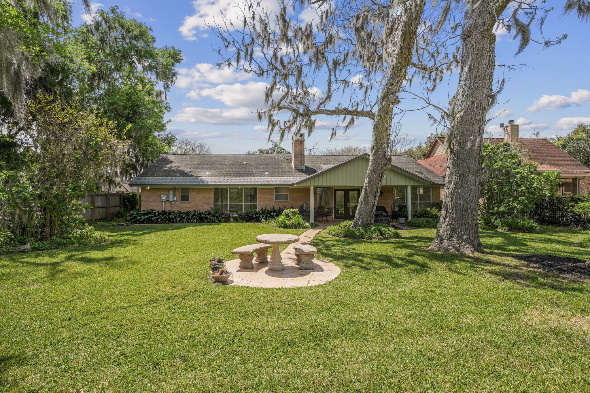 2261 Riverside Drive West Columbia, TX 77486 - Photo 37 of 44 View of back of home...the original builder installed concrete walkways around the home instead of gutters...Make sure you peek around both sides of the home...both spaces definitely gives a "Secret Garden" feel!