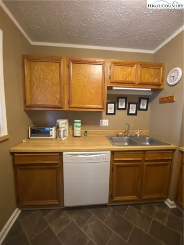 a view of a kitchen with granite countertop a sink and a stove