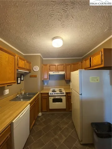 a kitchen with granite countertop a refrigerator and a sink