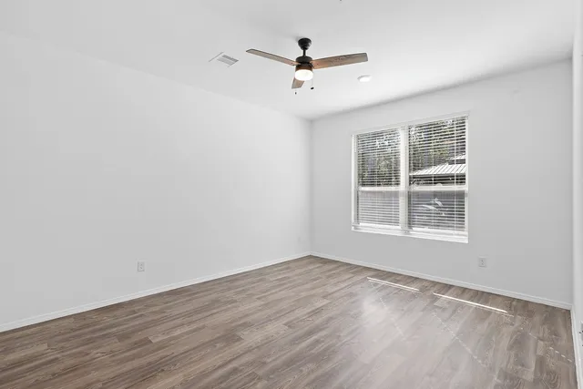 a view of a livingroom with wooden floor and a ceiling fan