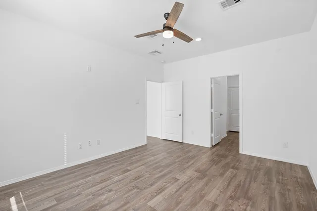 a view of an empty room with wooden floor