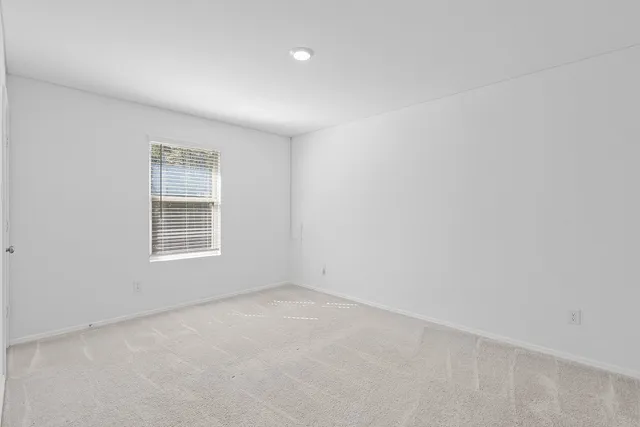 a front view of a house with a garden and trees