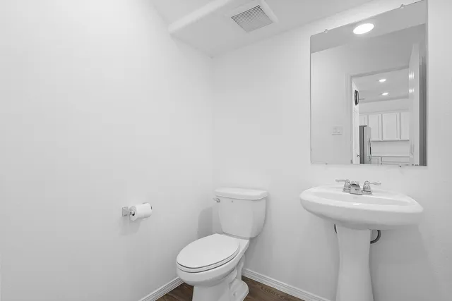 a bathroom with a sink toilet and a mirror