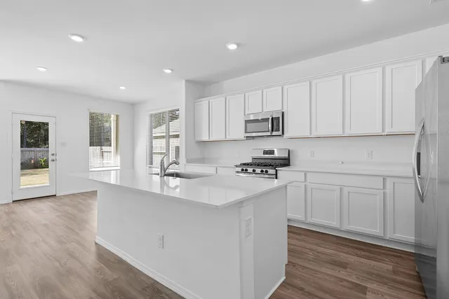 a kitchen with stainless steel appliances granite countertop a sink stove and cabinets