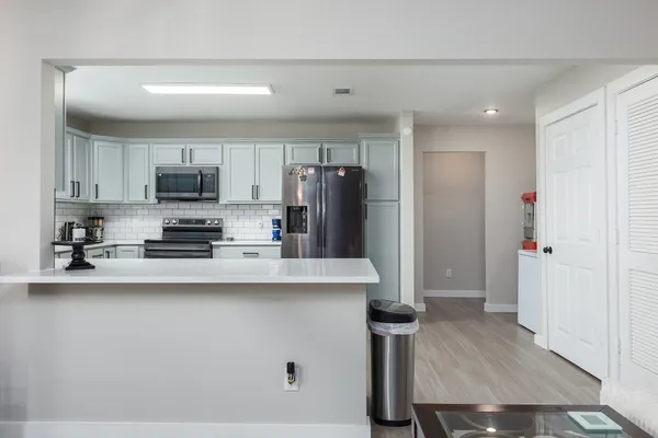 a kitchen with a refrigerator sink and cabinets