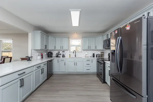 a kitchen with a sink cabinets and wooden floor
