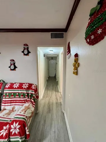 a hallway with a book shelf and wooden floor