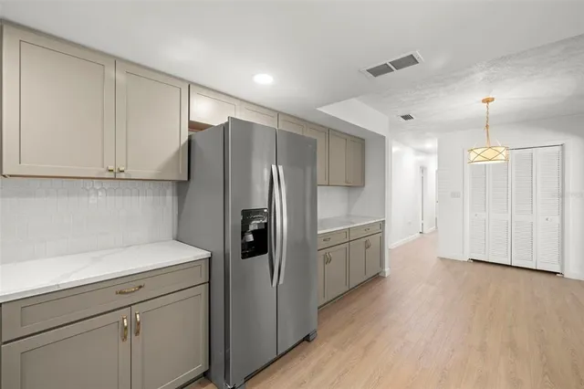 a kitchen with a refrigerator sink and cabinets