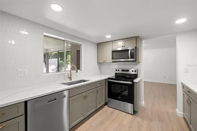 a kitchen with stainless steel appliances granite countertop a sink and a stove top oven