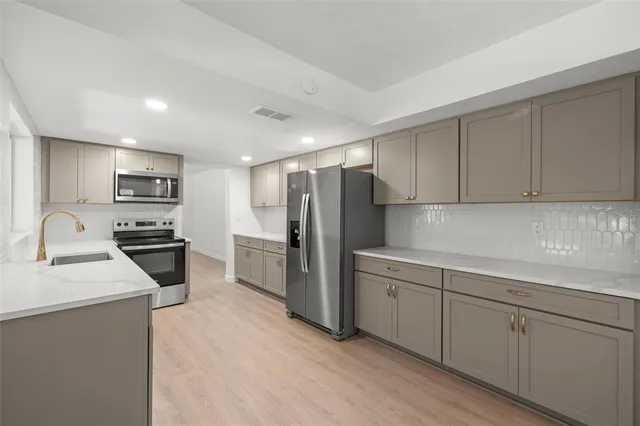a kitchen with refrigerator cabinets and a sink