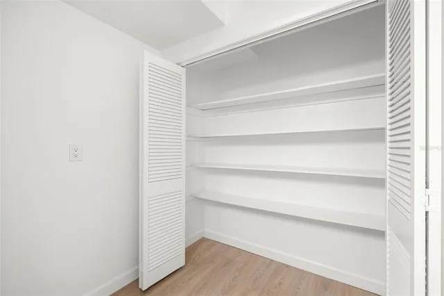 a view of walk in closet with empty racks