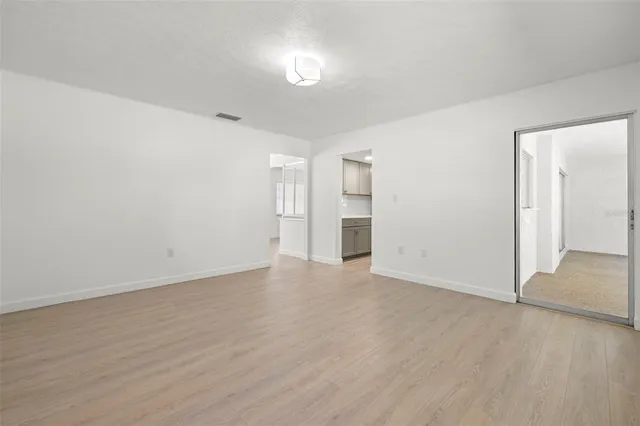 a view of an empty room with wooden floor