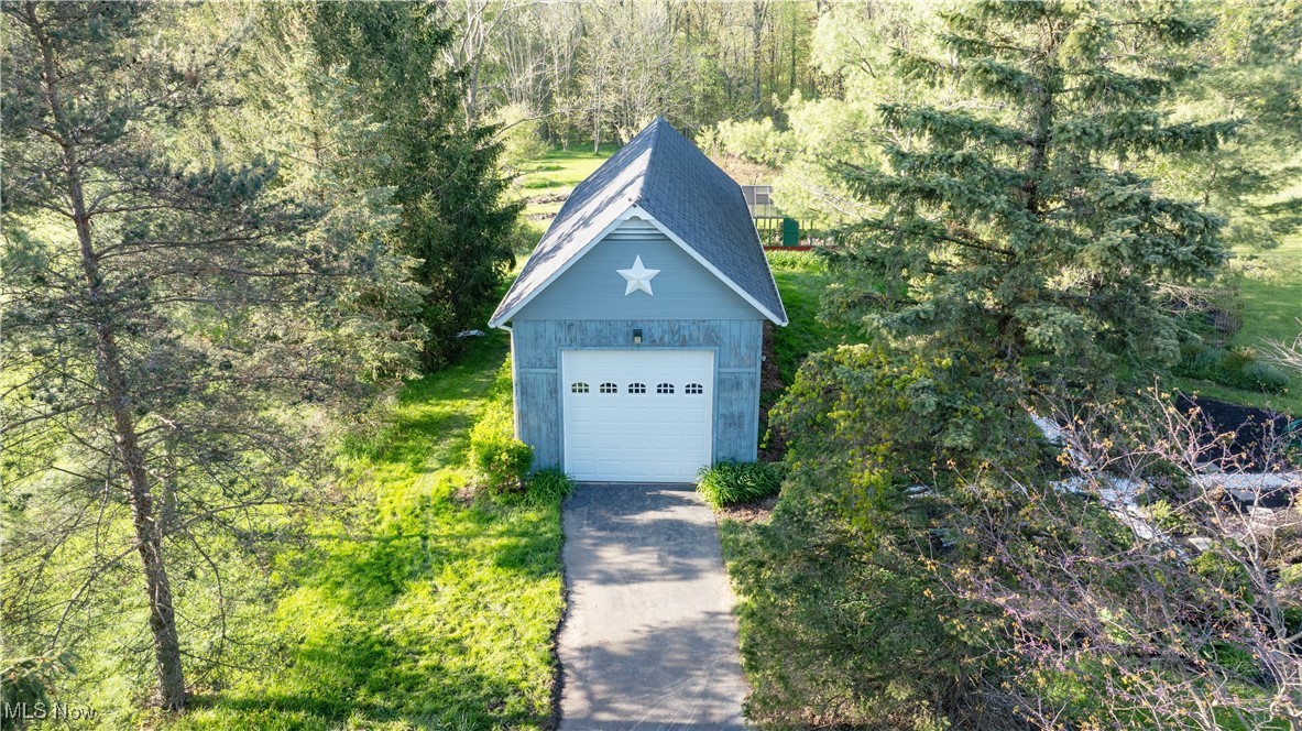 16140 Thompson Road Thompson, OH 44086 - Photo 7 of 50 Detached garage featuring concrete driveway and a forest view