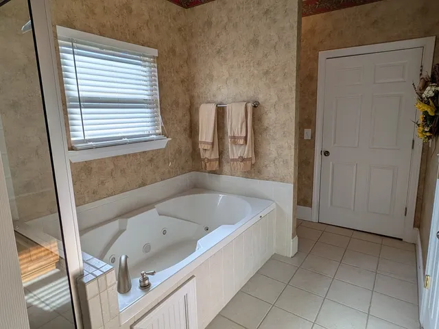 a bathroom with a tub a sink and a window