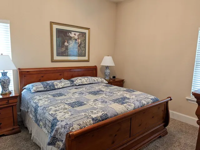 a bed sitting in a bedroom next to a lamp